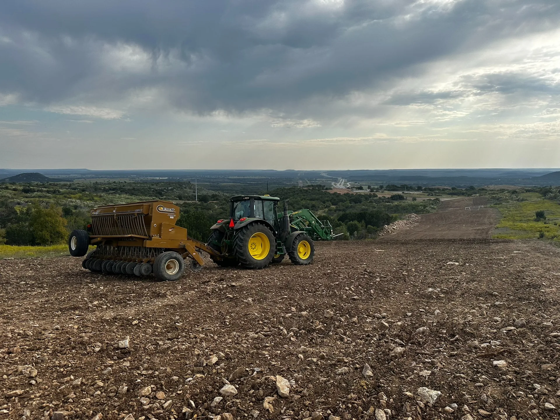 Tractor and seeding equipment on a rocky right-of-way
