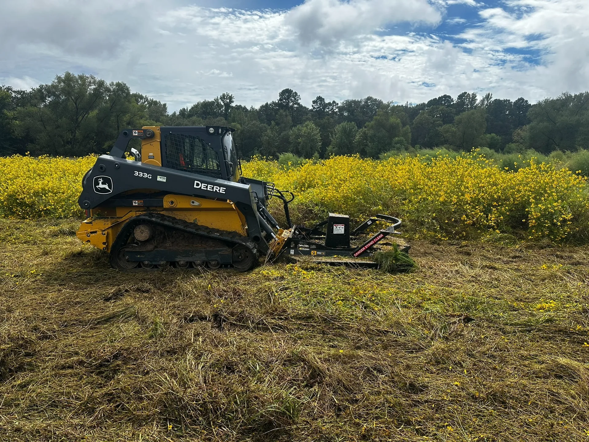 Compact track loader performing forestry mulching