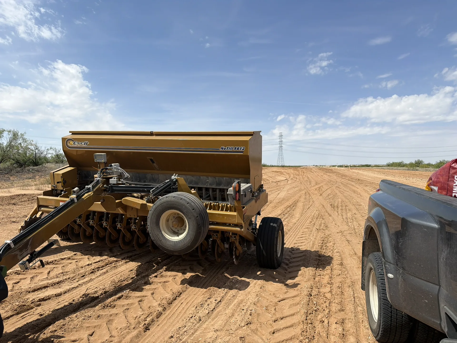 Seed drill staged beside a West Texas project